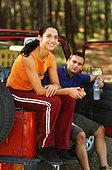 Young man and woman sitting on cross-country vehicle
