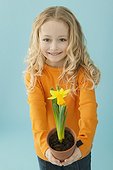 Little girl holding a potted daffodil