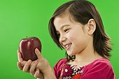 Smiling little girl holding an apple