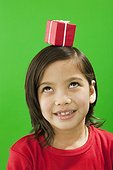 Little girl balancing a gift on her head