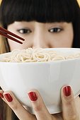 Young woman holding bowl of noodles