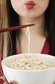 Woman holding cooling off a noodle