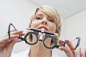 Eye doctor holding trial frames