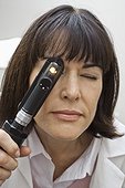 Eye doctor looking through an ophthalmoscope