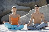 Couple meditating on beach