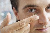 Man putting a contact lens in