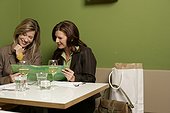 Two women discussing documents in a cafe