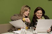 Two women looking at documents in a restaurant