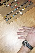A Board Game and Man's Hands on a Table (cropped)