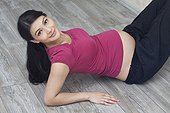 Pregnant woman lying on floor with legs raised