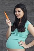 Pregnant woman holding carrot