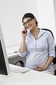 Pregnant woman on the phone in office