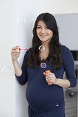 Pregnant woman blowing soap bubbles