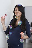 Pregnant woman blowing soap bubbles