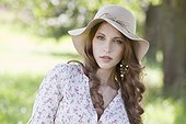 Brunette young woman wearing hat outdoors, portrait