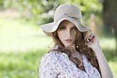 Brunette young woman wearing hat outdoors, portrait