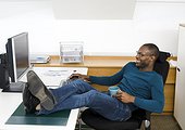 Man relaxing at desk in office