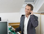 Businessman in office talking on mobile phone