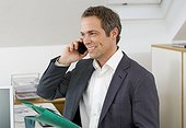 Businessman in office talking on mobile phone