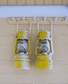 Two frozen lanterns hanging on hook