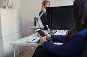 Woman in office using cell phone