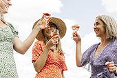 Female friends having wine on jetty