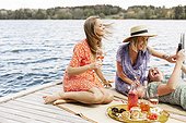 Female friends having picnic on jetty