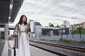 Woman using phone at train station platform