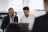 Men using laptop at business meeting