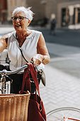 Senior woman standing near bicycle
