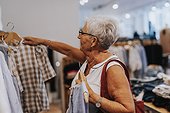 Senior woman looking at clothes in shop