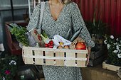 Woman carrying crate with organic vegetable