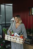 Woman carrying crate with organic vegetable