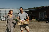 Smiling couple carrying shopping in crate