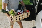 Man carrying crate with organic vegetable