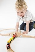 toddler boy playing with toy train set