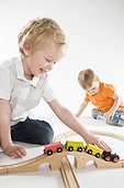 toddler boys playing with toy train set