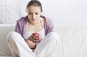 young woman with hot-water bottle on stomach