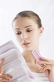 young woman reading pills leaflet