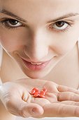 young woman with vitamins on hand
