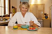 Woman seated at counter eating healthy breakfast