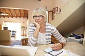 Woman writing checks in home office