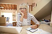 Woman writing checks in home office