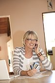 Woman at home office on phone with credit cards