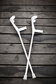 Top view of white crutches in cross shape on wood floor