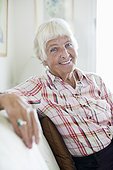 Portrait of smiling senior woman sitting on sofa