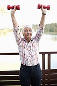 Active senior woman lifting hand weight doing exercise
