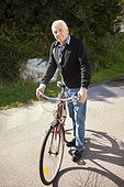 Active senior man with bicycle on a sunny day