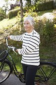 Active elder woman standing with bicycle