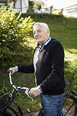 Happy senior man looking away with bicycle in park
